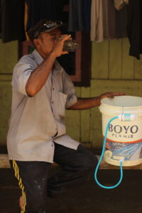 een man die wat van het gefilterde water drinkt