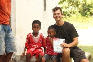 2 kinderen en een man van Groundswell Aid met het water filter
