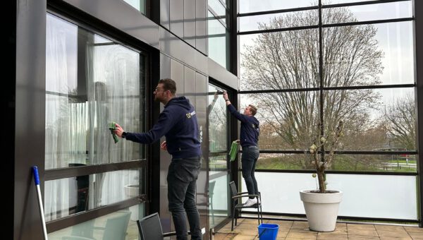 Twee Wentzo medewerkers die de ramen aan het schoonmaken zijn.